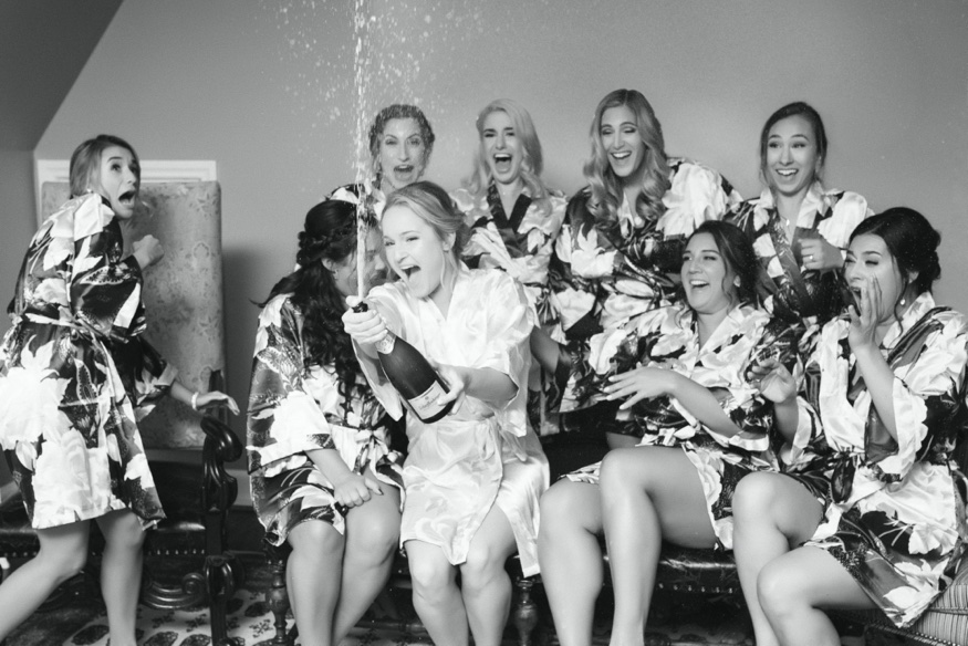 Bride and bridesmaid popping champagne at Moorestown Community Center wedding.